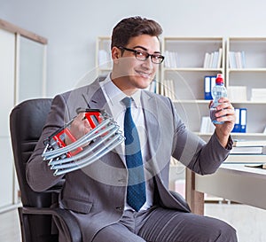 Young businessman exercising with elastic expander in office