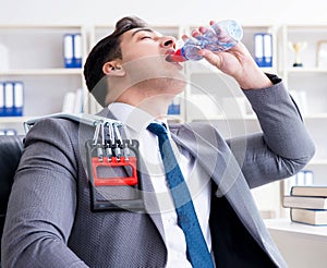 Young businessman exercising with elastic expander in office