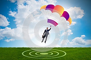 The young businessman falling on parachute in business concept