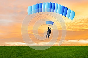 The young businessman falling on parachute in business concept