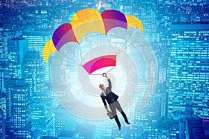 The young businessman falling on parachute in business concept