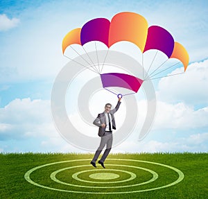 Young businessman falling on parachute in business concept