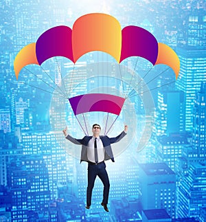 Young businessman falling on parachute in business concept