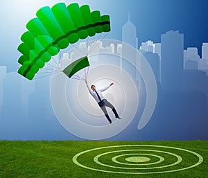 Young businessman falling on parachute in business concept