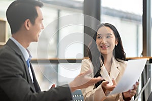 A young businessman and a female Asian accountant are discussing financial accounting and business planning together in