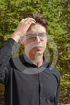 A young businessman fixes his hair with his hand. A man in a bla