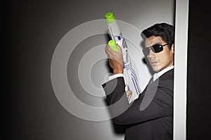 Young businessman fooling around with squirt gun. Conceptual image