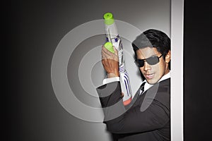 Young businessman fooling around with squirt gun. Conceptual image