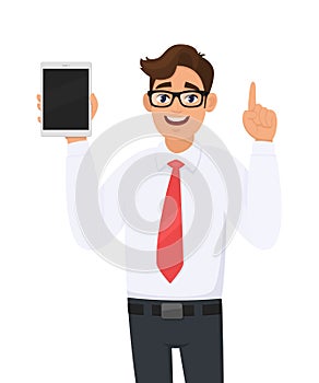 Young businessman in formal wear showing a digital tablet computer & pointing index finger upward. Person holding a latest tab.