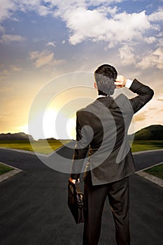 Young businessman in front of a crossroad