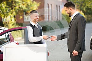 Young Businessman Getting Car Key From Valet