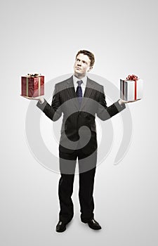 Young businessman with a gift boxes in his hands.