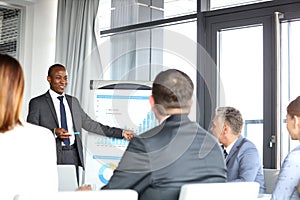 Young businessman giving presentation to colleagues in board room