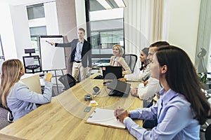 Businessman giving a presentation to his colleagues on a whiteboard in a boardroom