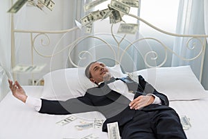 Young Businessman with happy, smile on the bed. who are successful in business and many banknote dollars money. business success