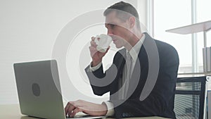 Young businessman happy working on laptop with internet online on desk for social distracting at home.