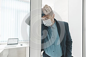 young businessman has fever and feel uncomfortable in office. An employee in the office got sick with covid 19