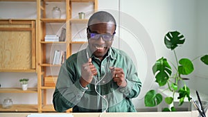 Young businessman having fun and listening to music at table in modern office spbas.