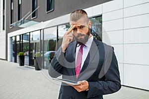 Young businessman having headache because of problems at work.