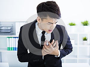 Young businessman having heart attack and chest pain