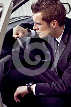 Young businessman in his car at the wheel