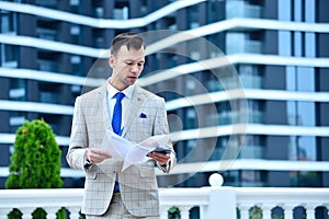 Young businessman holding business contract and mobile phone