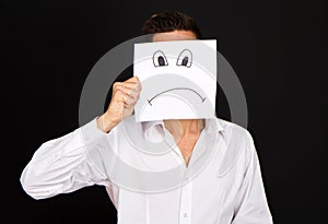 A Young businessman holding card with a angry face