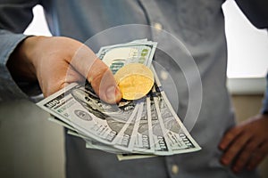 Young businessman holding dollar and coin of bitcoin in hand