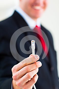 Young businessman holding an ethernet cable