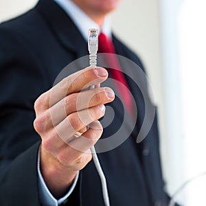 Young businessman holding an ethernet cable