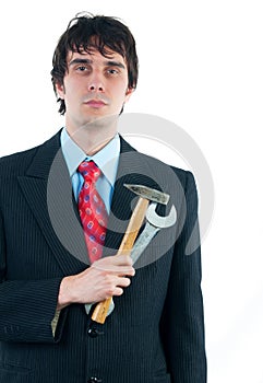 Young businessman holding hammer and wrench as metaphore of his