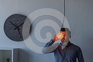 young businessman holding illuminated light bulb while standing