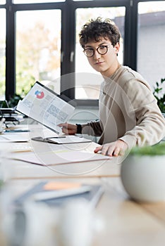 Young businessman holding papers with chats