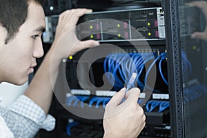 Young businessman holding and plugging in a computer cable photo