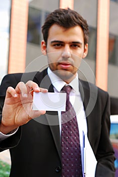 Young businessman holding visit card