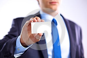 Young businessman holds out his hand with a business card