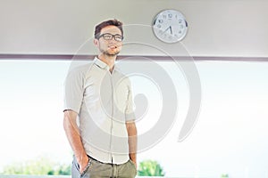 Young businessman in interior with the clock