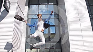 Young businessman jumping with joy, slow motion