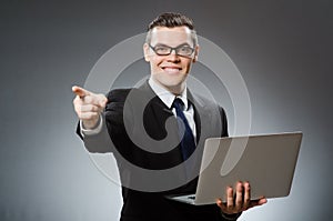 The young businessman with laptop in business concept