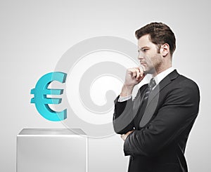 Young businessman look at the blue Euro sign on a