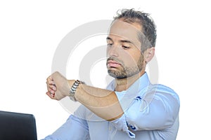 A young businessman looking at his watch