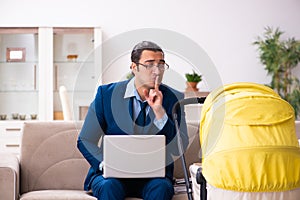 Young businessman looking after newborn at home