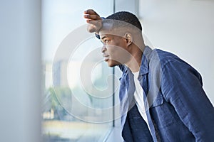 Young businessman looking out the window in an office