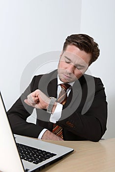 Young businessman looking at wrist watch