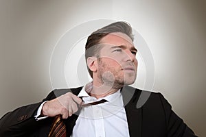 Young businessman loosening a tie