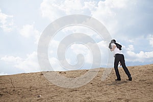 Young businessman lost and walking through the desert