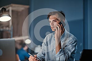 young businessman making a call from the office at night.