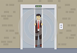 Young businessman or manager trying to open the doors. Broken elevator.