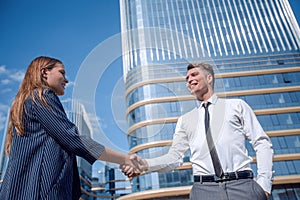 Young businessman meeting a young professional with a handshake.