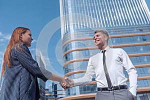 Young businessman meeting a young professional with a handshake.